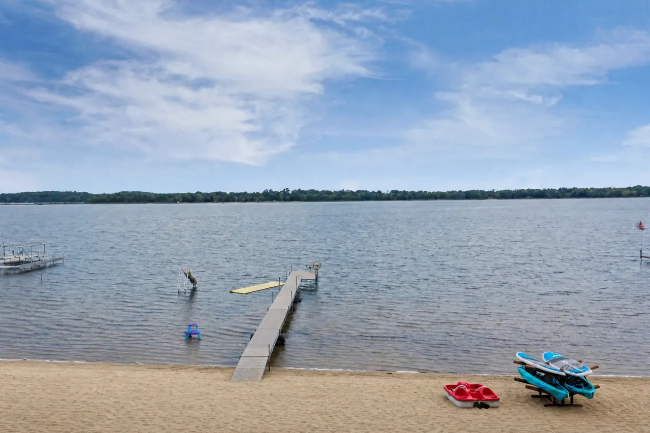 The dock reaching into the lake under a wide summer sky