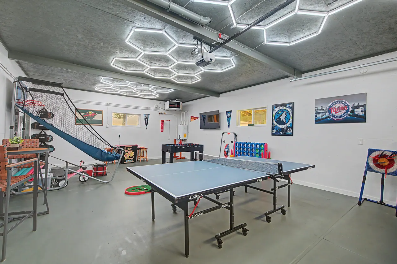 Game room with ping pong, foosball and a basketball arcade under hexagon lights