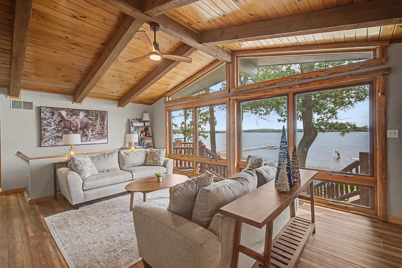 Great room with a vaulted cedar ceiling and a wall of windows on the lake