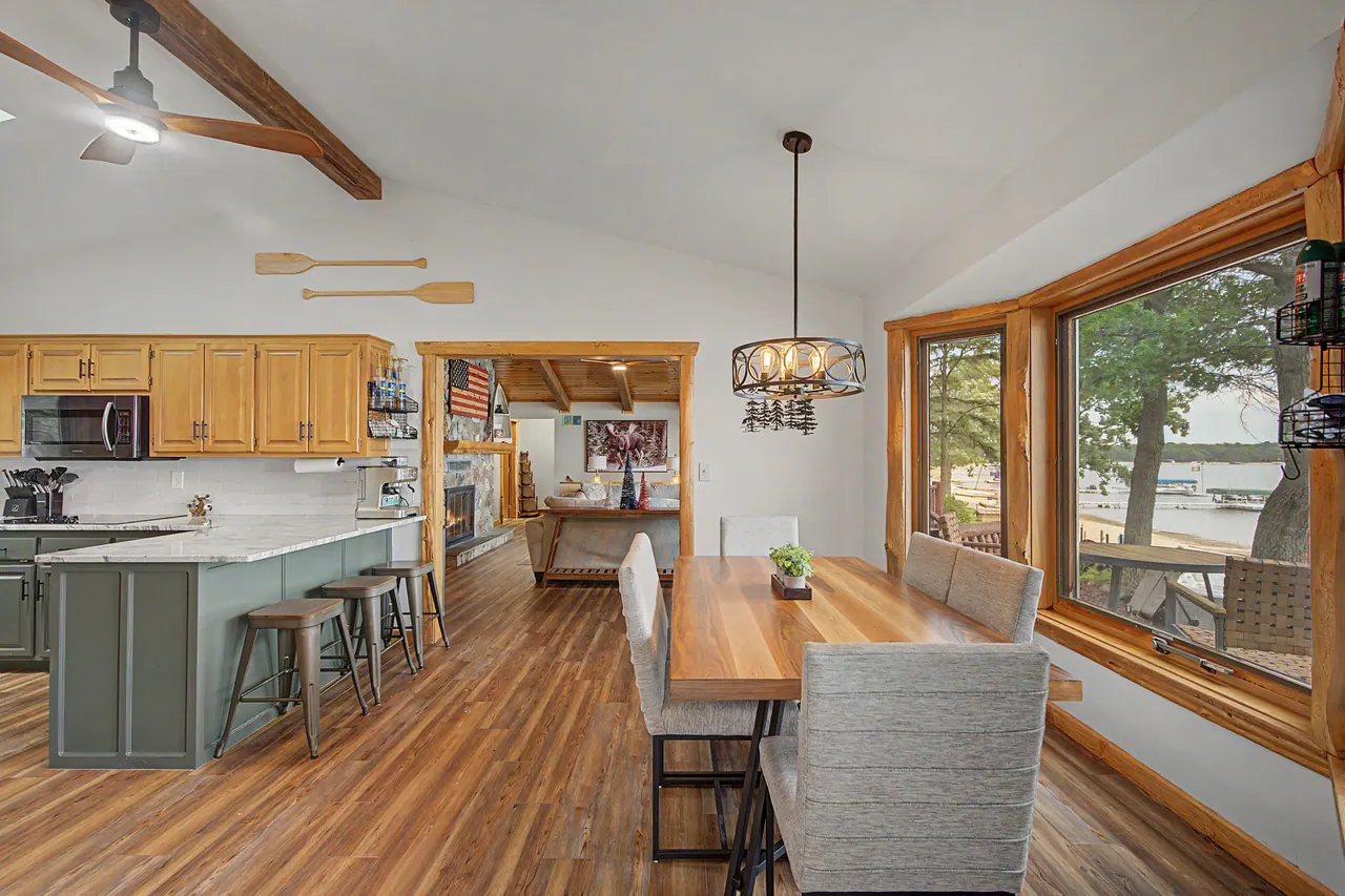 Kitchen island and long dining table beside the lake windows